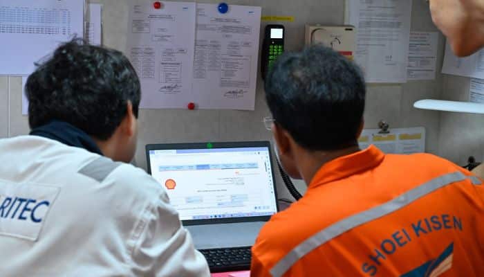 The cargo officer and surveyor completing the bunkering documents electronically on ONE Truth