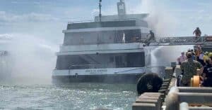 Firefighters boarding the Spirit of Norfolk during firefighting efforts.